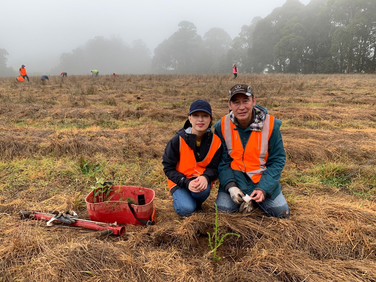 smartgroup two people partaking in the tree planting in a field